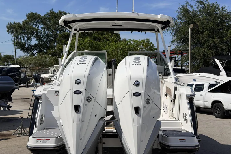 Slide: The Image of 2023 Blackfin 272 DC boat with dual outboard engines, displayed outdoors. - 22