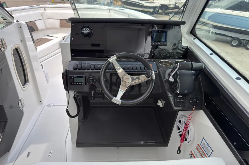 Slide: The Image of 2023 Blackfin 272 DC boat cockpit with steering wheel and control panel. - 14
