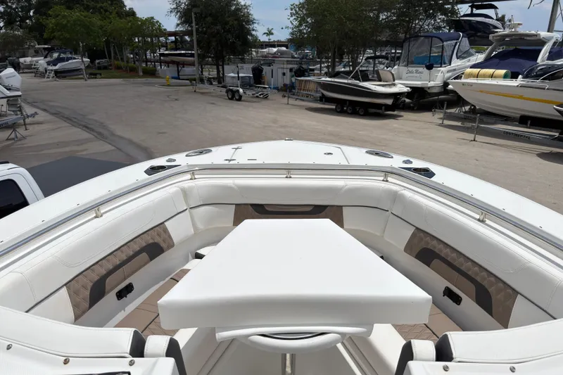Slide: The Image of 2023 Blackfin 272 DC boat interior with seating and table, docked at marina. - 18