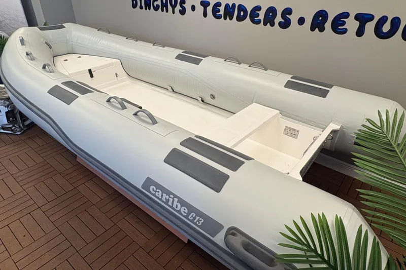 Slide: The Image of Inflatable Caribe C-13 boat, 2026 model, displayed indoors with wooden flooring. - 4