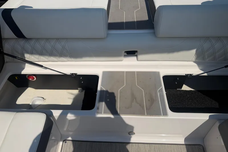 Slide: The Image of 2019 Regal 2100 boat interior with open storage compartments and cushioned seating. - 22
