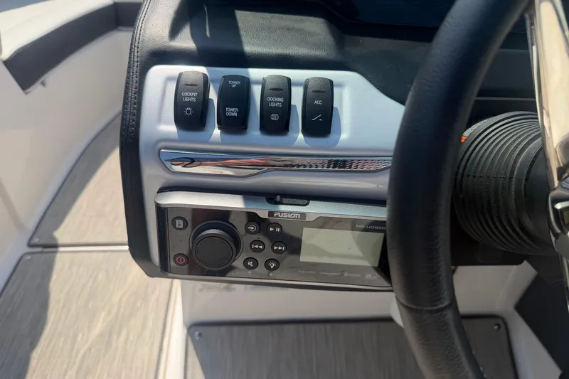Slide: The Image of Control panel of a 2019 Regal 2100 boat with switches and audio system. - 12