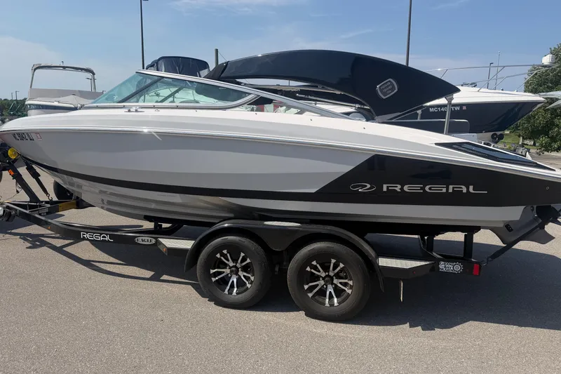 Slide: The Image of 2019 Regal 2100 boat on trailer, parked outdoors under clear sky. - 3