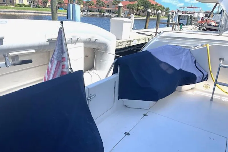 Slide: The Image of 1996 Sea Ray 500 Sedan Bridge yacht deck with blue covers and American flag. - 23