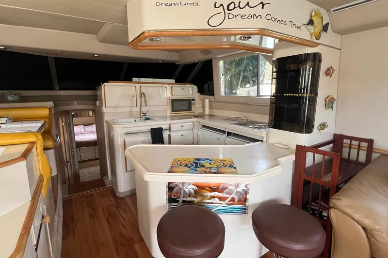 Slide: The Image of Interior of a 1996 Sea Ray 500 Sedan Bridge yacht with kitchen and seating area. - 12