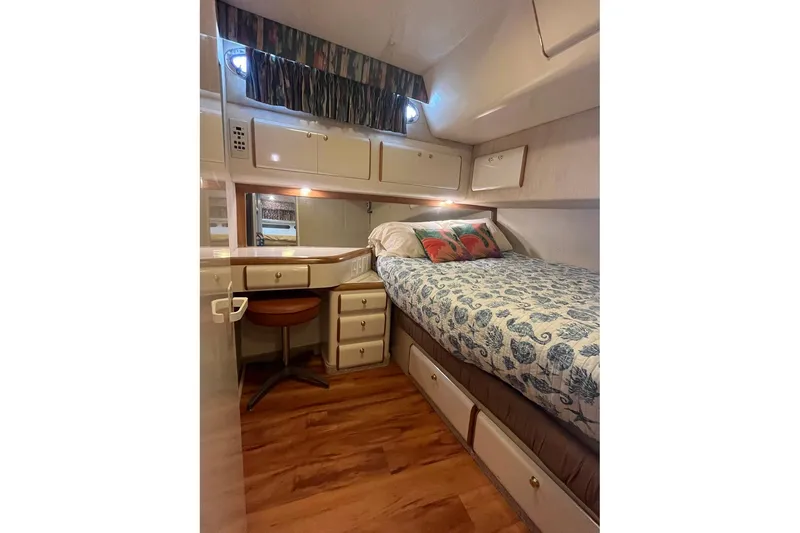 Slide: The Image of Cozy cabin interior of 1996 Sea Ray 500 Sedan Bridge with bed and wooden flooring. - 11