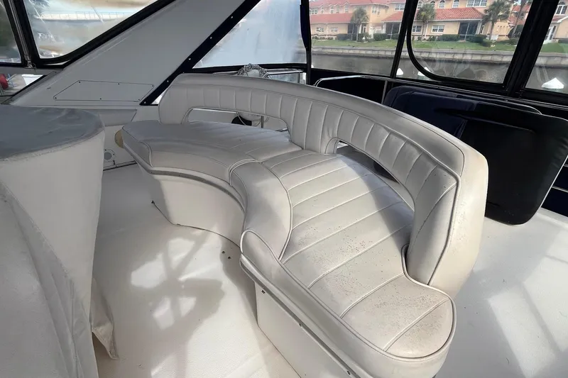 Slide: The Image of 1996 Sea Ray 500 Sedan Bridge interior with curved white leather seating. - 23