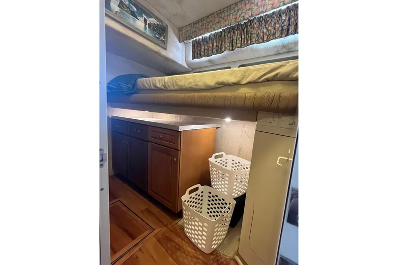 Slide: The Image of Interior of 1996 Sea Ray 500 Sedan Bridge with bunk bed and storage cabinets. - 9