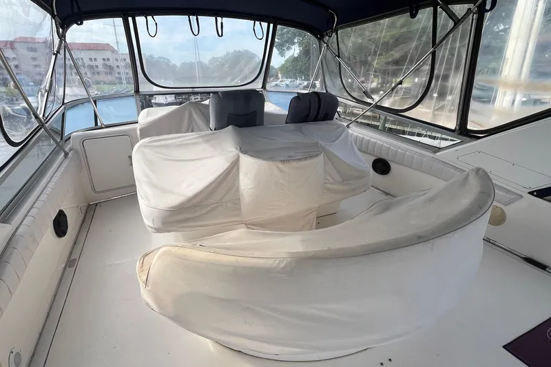 Slide: The Image of 1996 Sea Ray 500 Sedan Bridge interior with covered seating and panoramic windows. - 22