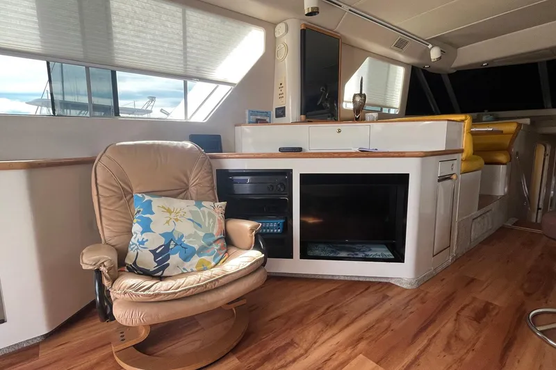 Slide: The Image of Interior of a 1996 Sea Ray 500 Sedan Bridge yacht with leather chair and floral pillow. - 13