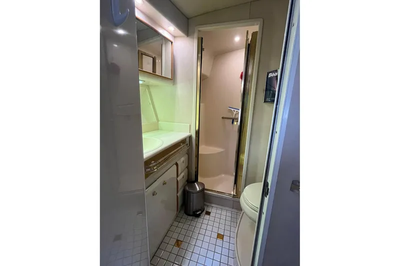 Slide: The Image of Bathroom interior of 1996 Sea Ray 500 Sedan Bridge yacht, featuring shower and vanity. - 8