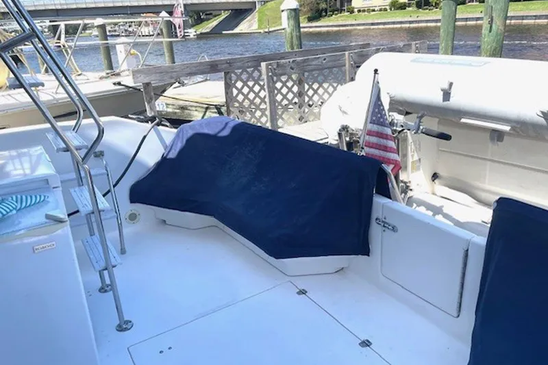 Slide: The Image of 1996 Sea Ray 500 Sedan Bridge yacht deck with covered seating and American flag. - 28