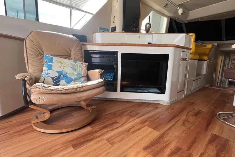 Slide: The Image of Interior of 1996 Sea Ray 500 Sedan Bridge with leather chair and floral cushion. - 14