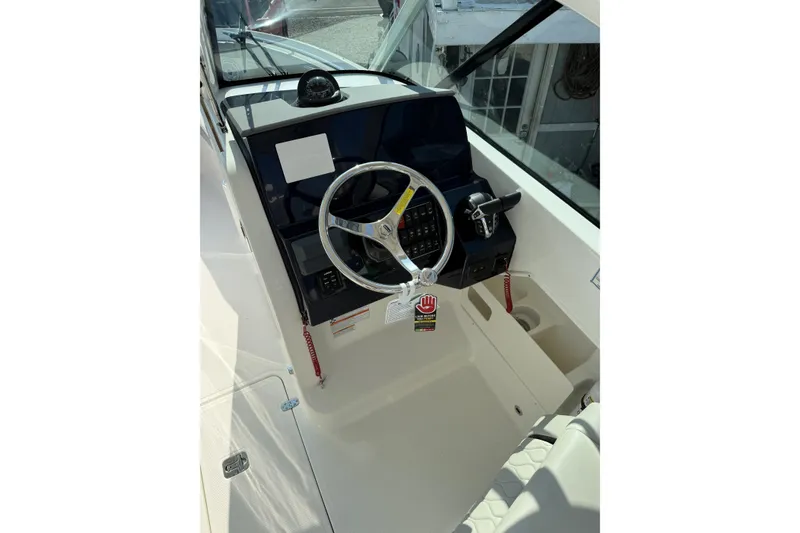 Slide: The Image of 2027 Pursuit DC 266 Dual Console boat helm with steering wheel and control panel. - 9