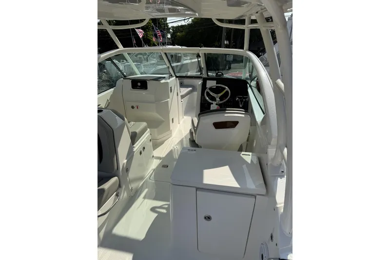 Slide: The Image of 2027 Pursuit DC 266 Dual Console boat interior with steering wheel and seating area. - 5