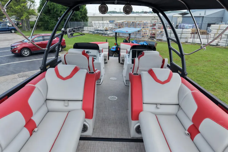 Slide: The Image of 2020 Monterra Surf boat interior with red and white seating, parked near vehicles and greenery. - 16