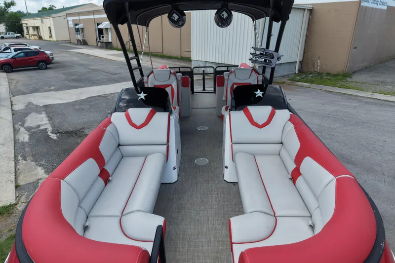 Slide: The Image of 2020 Monterra Surf boat with red and white seating, parked in an industrial area. - 8