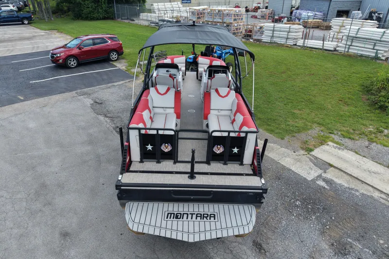 Slide: The Image of Aerial view of 2020 Monterra Surf boat with red and white seating, parked near grass. - 2
