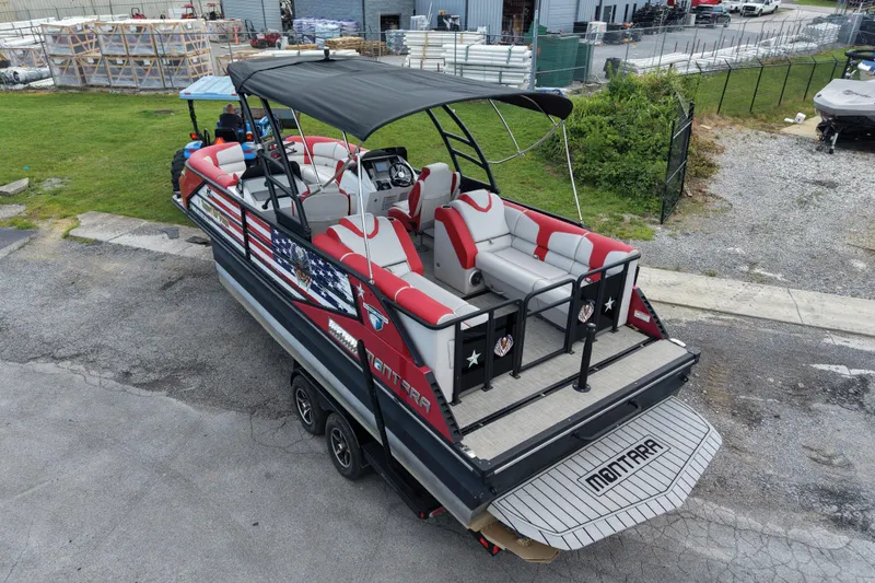 Slide: The Image of 2020 Monterra Surf boat with red and gray seating, parked outdoors. - 7