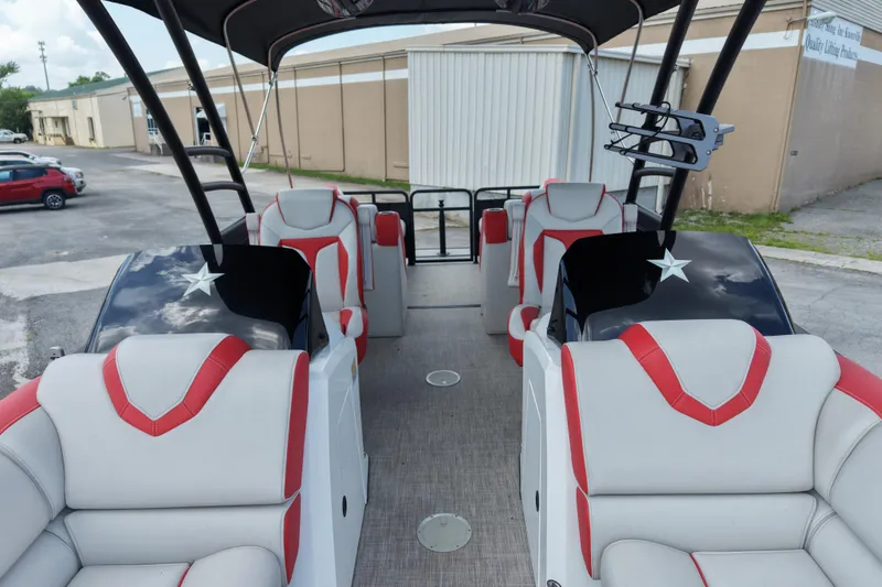 Slide: The Image of 2020 Monterra Surf boat interior with red and white seating, parked outdoors. - 15