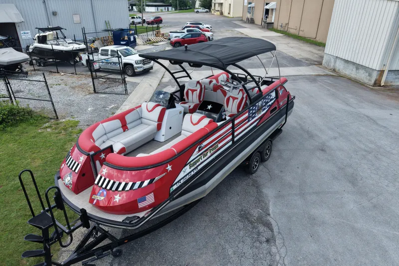 Slide: The Image of 2020 Monterra Surf boat with patriotic design, parked on a trailer near industrial buildings. - 4