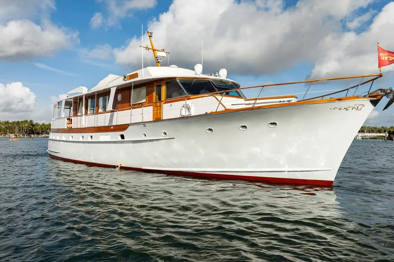 Slide: The Image of 1972 Trumpy 72 Motor Yacht on calm water under a partly cloudy sky. - 2