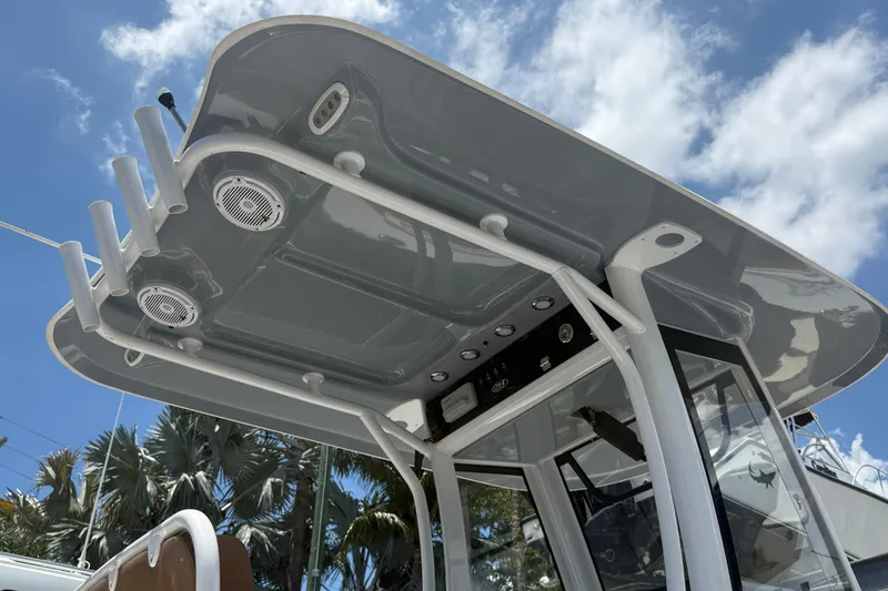 Slide: The Image of 2020 Sea Hunt Ultra 275 SE boat canopy with speakers and rod holders under blue sky. - 6