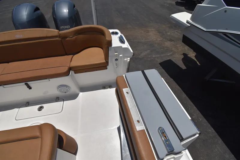 Slide: The Image of 2020 Sea Hunt Ultra 275 SE boat interior with brown seating and dual engines. - 19