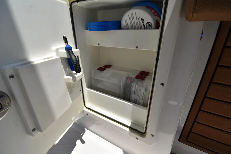 Slide: The Image of Storage compartment on a 2020 Sea Hunt Ultra 275 SE boat, featuring organized shelves and tools. - 9