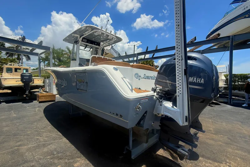 Slide: The Image of 2020 Sea Hunt Ultra 275 SE boat with Yamaha engine, docked under a sunny sky. - 1