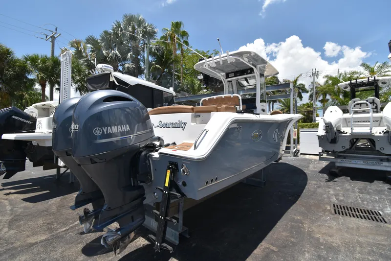 Slide: The Image of 2020 Sea Hunt Ultra 275 SE boat with Yamaha engines, parked outdoors under a clear sky. - 4