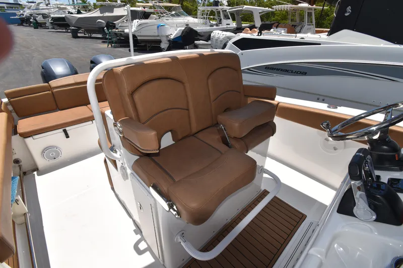 Slide: The Image of 2020 Sea Hunt Ultra 275 SE boat interior with brown seating and steering console. - 8