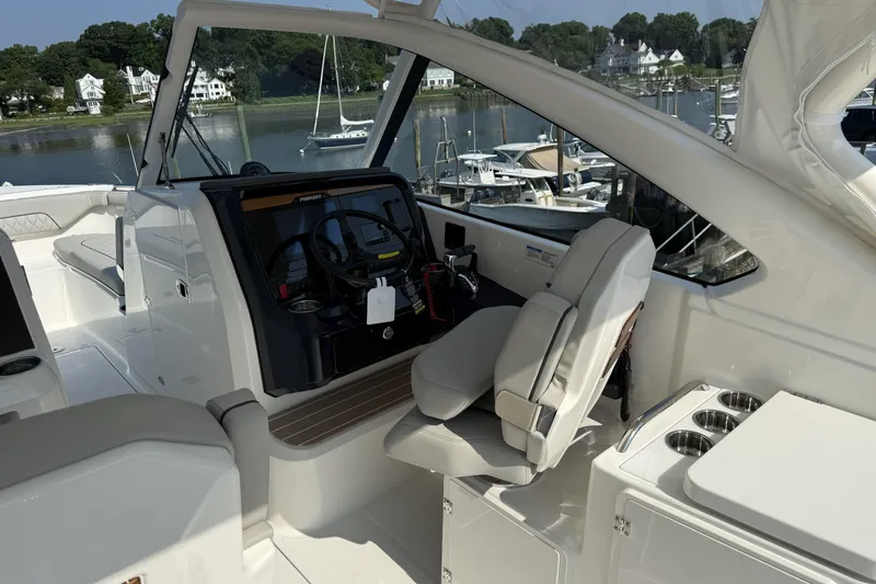 Slide: The Image of 2027 Pursuit DC 286 Dual Console boat interior with helm, seating, and waterfront view. - 8