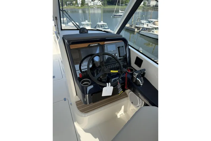 Slide: The Image of Helm of 2027 Pursuit DC 286 Dual Console boat with steering wheel and controls. - 12