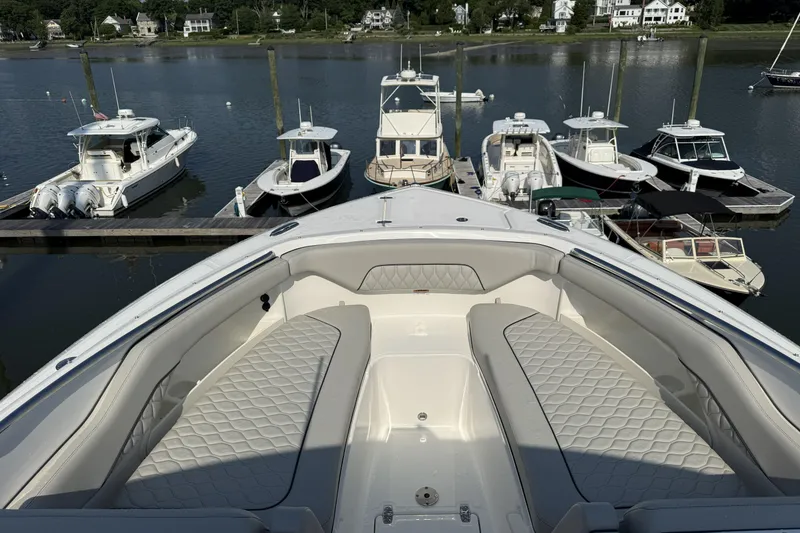 Slide: The Image of 2027 Pursuit DC 286 Dual Console boat docked, featuring spacious seating and elegant design. - 13