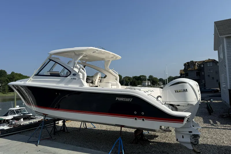 Slide: The Image of 2027 Pursuit DC 286 Dual Console boat with Yamaha engine, displayed outdoors on stands. - 2