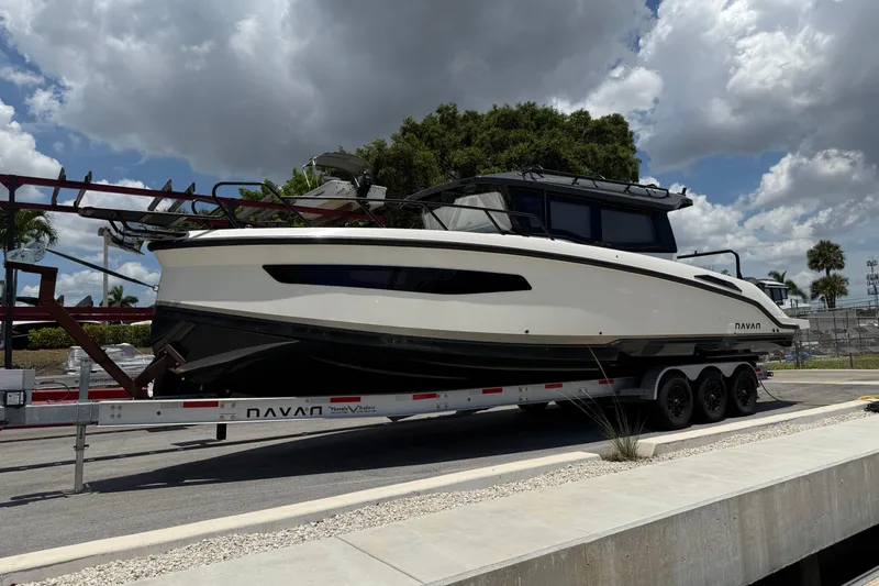 Slide: The Image of 2024 Navan C30 boat on trailer under cloudy sky, parked near dock. - 6