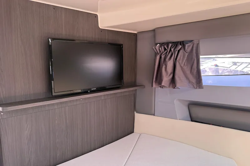 Slide: The Image of Interior of 2024 Navan C30 featuring a mounted TV and window with curtain. - 23