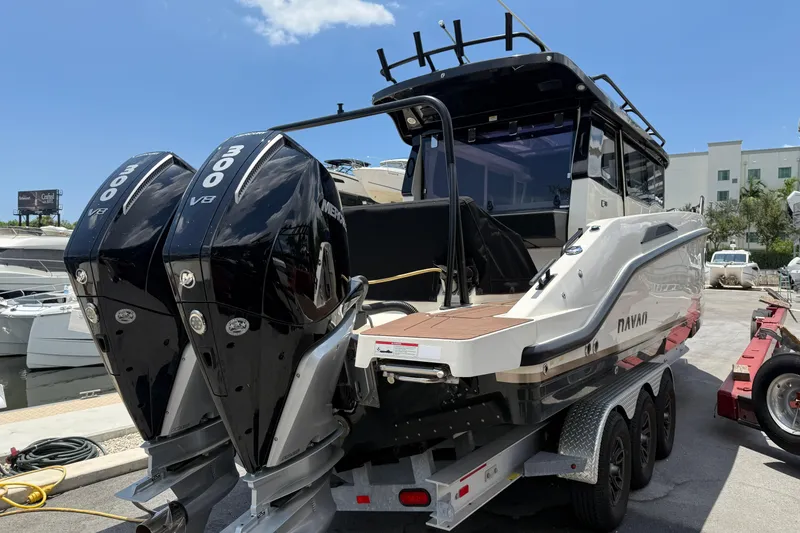 Slide: The Image of 2024 Navan C30 boat with dual 300 V8 engines on a trailer at a marina. - 4
