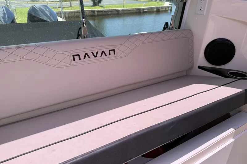 Slide: The Image of 2024 Navan C30 boat interior with cushioned seating and speaker, near water. - 16