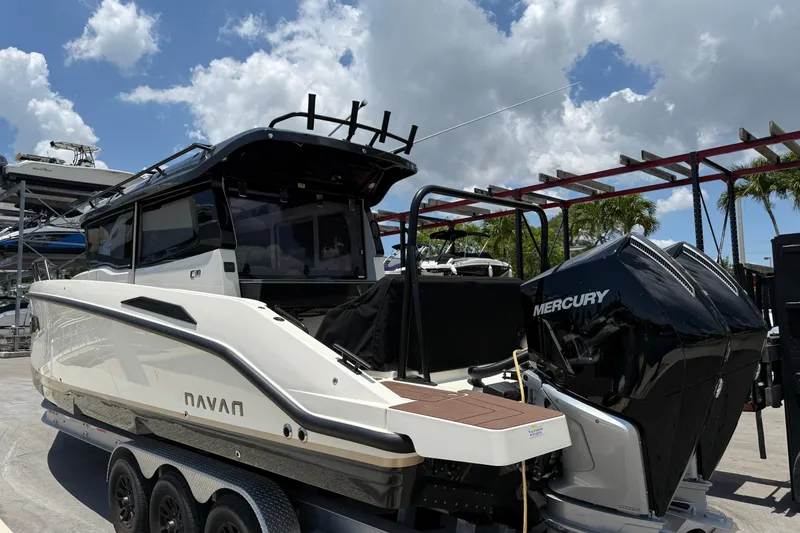 Slide: The Image of 2024 Navan C30 boat with Mercury engines on a trailer under a cloudy sky. - 2