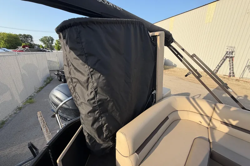 Slide: The Image of 2023 Godfrey Sweetwater 2286 C pontoon boat with covered engine and beige seating. - 8