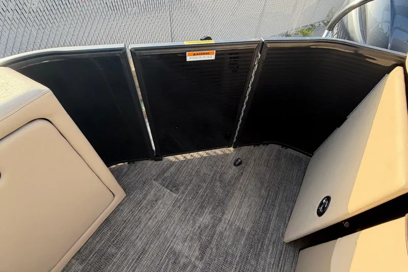 Slide: The Image of Interior view of 2023 Godfrey Sweetwater 2286 C pontoon boat with beige seating and carpeted floor. - 7