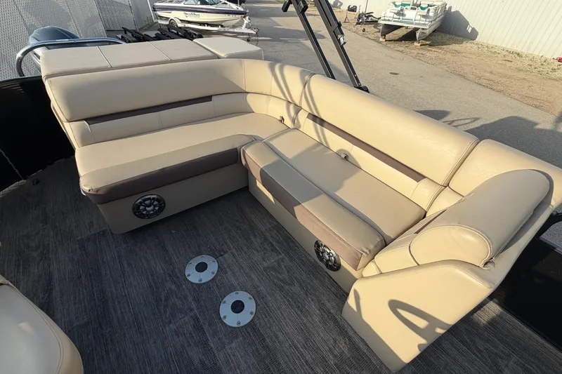 Slide: The Image of 2023 Godfrey Sweetwater 2286 C boat interior with beige seating and speakers. - 5