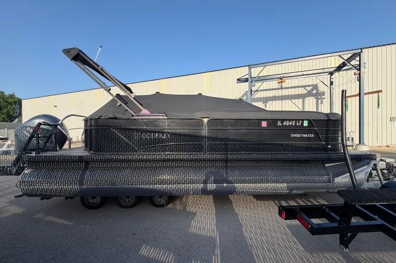 The Image of 2023 Godfrey Sweetwater 2286 C pontoon boat with cover, parked on a trailer. - 2