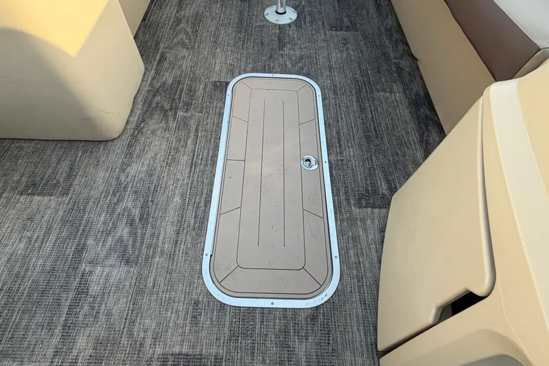 Slide: The Image of Floor hatch on 2023 Godfrey Sweetwater 2286 C boat, featuring textured carpet and beige seating. - 19