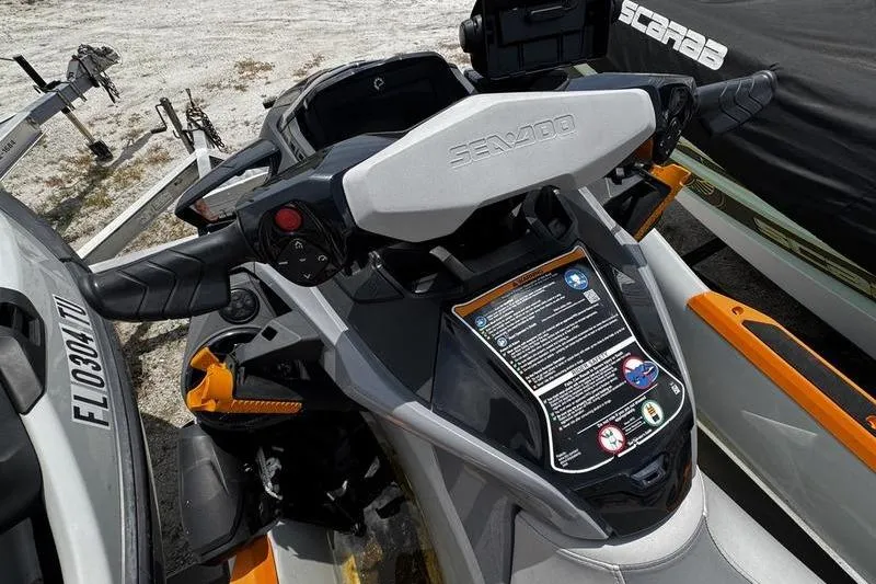 Slide: The Image of 2023 Sea-Doo FishPro Trophy dashboard with controls and display, parked on sandy terrain. - 12