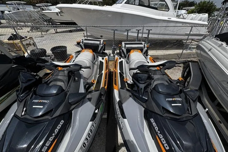 Slide: The Image of 2023 Sea-Doo FishPro Trophy jet skis parked at a marina, ready for adventure. - 14