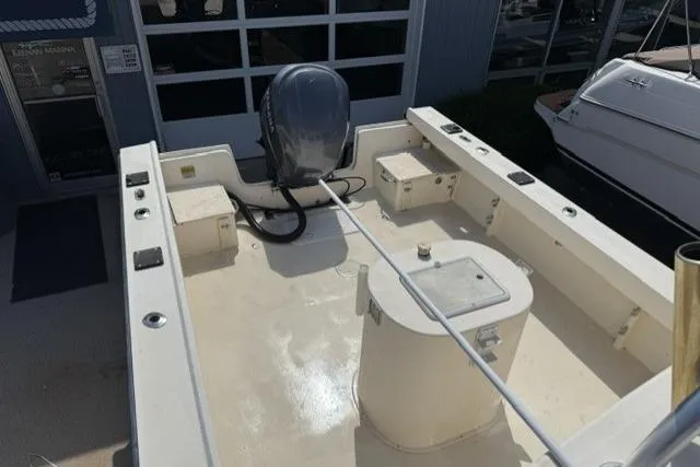 Slide: The Image of 2006 Parker 2520 SL Sport Cabin boat deck with outboard motor, docked near other boats. - 6