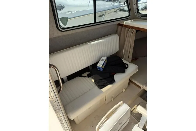 Slide: The Image of Interior of a 2006 Parker 2520 SL Sport Cabin with white seating and window view. - 13